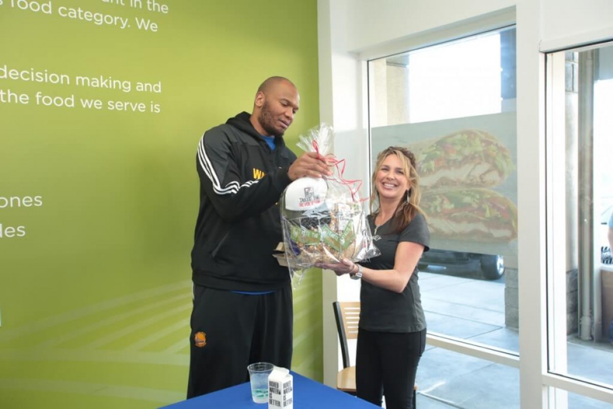 Marreese Speights receiving a gift basket
