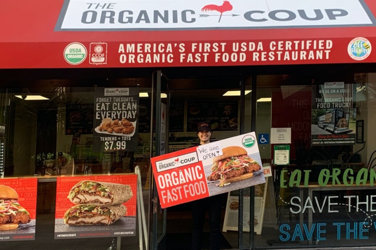 The Organic Coup employee holding a sign
